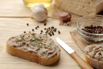 Fresh homemade chicken liver pate with herbs for bread on a natural wooden table. A sandwich. close-up