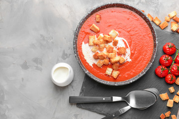 Bowl of tasty tomato cream soup on grunge background