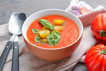 Bowl of tasty tomato cream soup on table