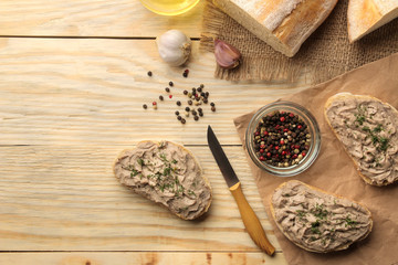 Fresh homemade chicken liver pate with herbs for bread on a natural wooden table. A sandwich. top view