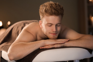 Handsome young man relaxing in spa salon