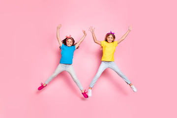 Full size photo of stylish cheerful kids moving raise hands arms wear pants trousers isolated over pink background
