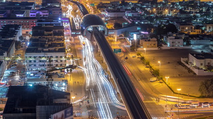 Fototapeta na wymiar Metro station and traffic on the night road timelapse. Aerial view from the top of the building.