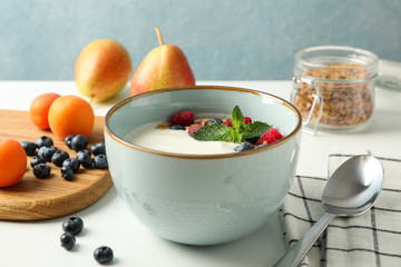 Composition with yogurt dessert and ingredients on white background, space for text