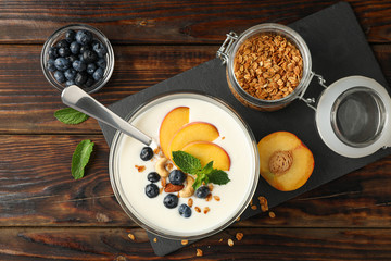 Composition with yogurt dessert and ingredients on wooden background, space for text