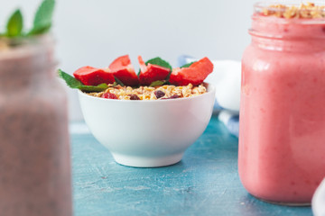 Bowl of homemade granola with yogurt and fresh berries on wooden background