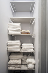  white linens and towels on the shelves