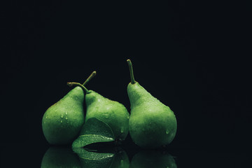 Fototapeta na wymiar Beautiful fresh pears on a black glass table dark background.