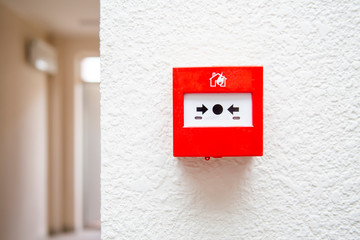fire alarm hang on a light wall, near door