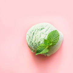 One green pistachio or matcha tea ice cream ball with mint on pink background. View from above.