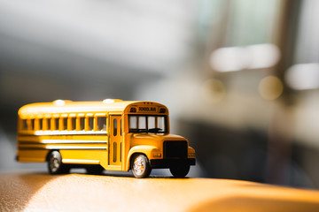 Miniature yellow school bus with sunlight