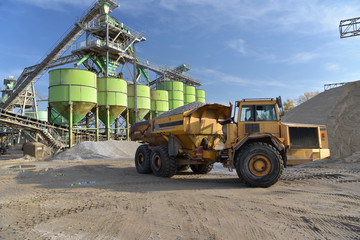 Obraz premium Abbau von Sand in einem Kieswerk - Anlage mit Förderbändern,Silos und Gebäuden // Mining of sand in a gravel plant - plant with conveyor belts and buildings
