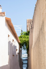 Ruelle étroite avec vue sur le port de plaisance sur l'île de Porquerolles, Var, Provence, France