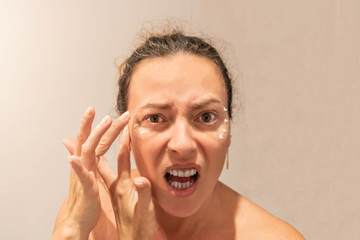 Femme appliquant de la crème anti-ride sur le contours de ses yeux
