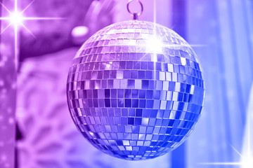Disco ball with bright rays of lights, party background