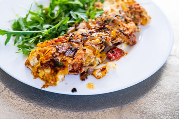 Omelete with arugula on white plate