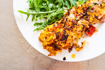 Omelete with arugula on white plate