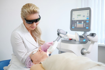 Woman getting treatment with aesthetic dermatology device