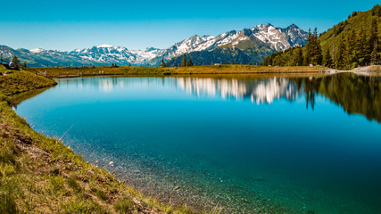 Fototapeta na wymiar Beautiful alpine view and a lake with reflections taken with a ND grey filter at Rauris, Salzburg, Austria