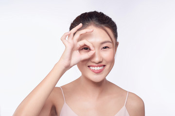 Young woman, makes ok sign, covers her eye