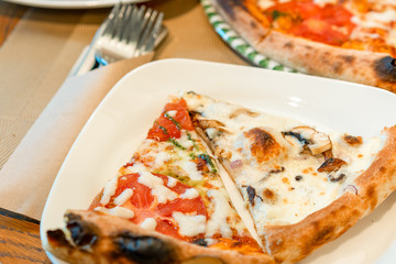 Slice of tasty italian pizza on a plate in restaurant