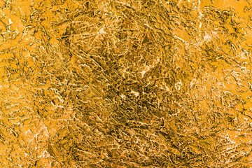 The texture of the plaster on the wall is painted in gold. Background.