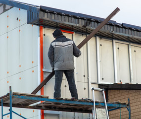 Worker installs plastic panels with bricks