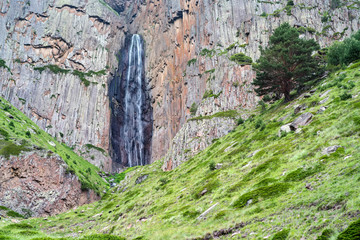 Summer landscape with mountain waterfall between two rocks