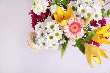 Ramo de flores colorido sobre fondo blanco, con margaritas, gerberas y lirios.