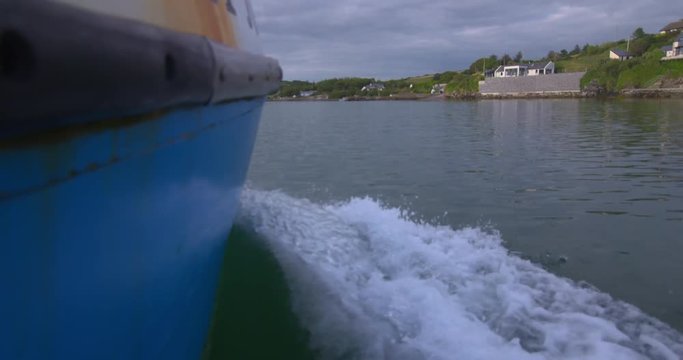Boat trip Ireland harbour approaching pier bow wave wake summer vacation
