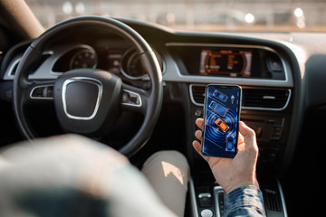 Handsome man using mobile phone while driving.