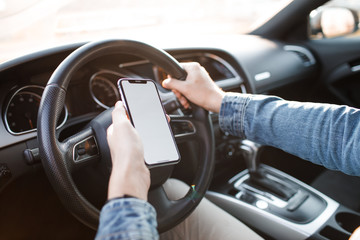 Handsome man using mobile phone while driving.