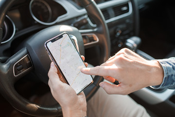 Handsome man using mobile phone while driving.