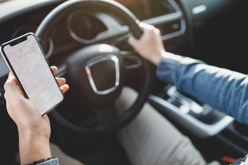 Handsome man using mobile phone while driving.
