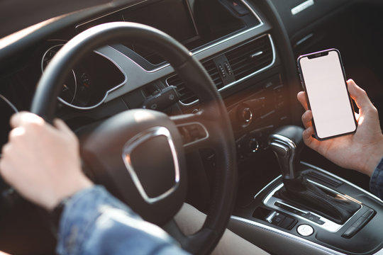 Handsome man using mobile phone while driving.