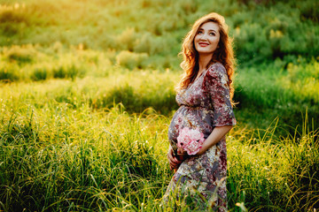 Portrait of beautiful pregnant woman in a field