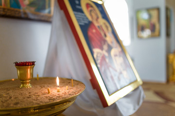 Naklejka na ściany i meble icon and burning candle in the orthodox temple interior