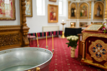baptistery with burning candles in the orthodox temple interior