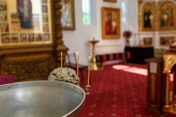 baptistery with burning candles in the orthodox temple interior