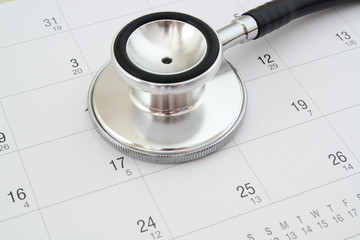 Regular medical examination concept, stethoscope on calendar background