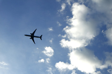 Airplane flying and clear blue sky with white clouds