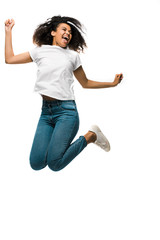 cheerful african american woman gesturing while celebrating and jumping isolated on white