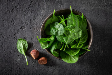 Raw green spinach on gray stone table