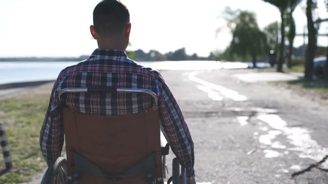 A man in a wheelchair walks on the waterfront