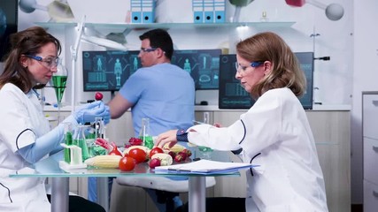 Female scientist testing GMO samples on vegetables in modern laboratory - Powered by Adobe