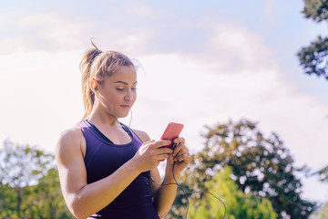 athletic woman setting up phone app before run