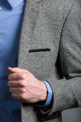 Confident businessman. Cropped shot of businessman in stylish suit holds the lapel of his jacket.