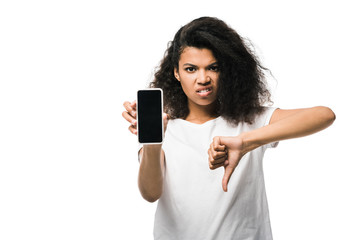 displeased african american girl holding smartphone with blank screen and showing thumb down isolated on white