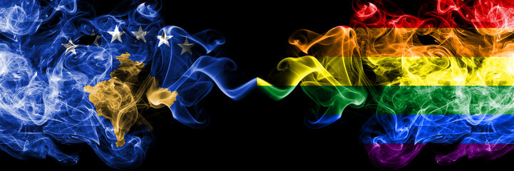 Kosovo vs Gay pride smoky mystic flags placed side by side. Thick colored silky smokes combination of Kosovo and Gay pride flag