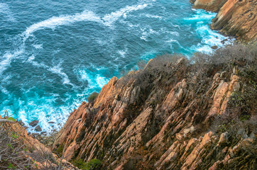Blue sea with rocky shore in sunny afternoon